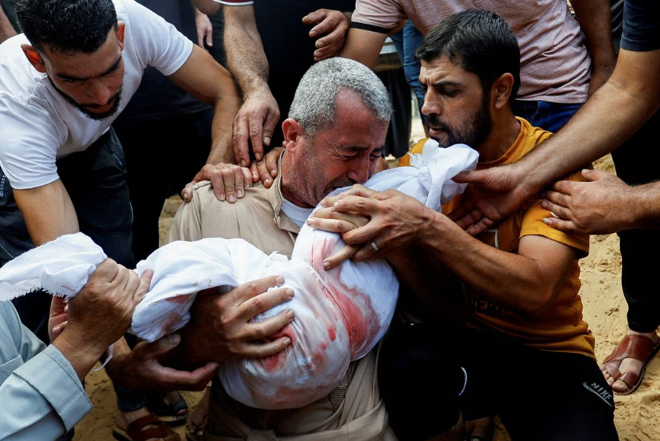 Reaksi seorang pelayat saat menguburkan jenazah anak Palestina dari keluarga al-Agha, yang tewas dalam serangan Israel, di Khan Younis di Jalur Gaza selatan, 11 Oktober. REUTERS/Ibraheem Abu Mustafa