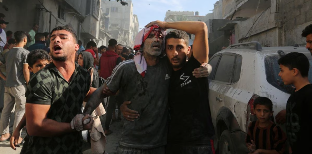 Seorang warga Palestina yang terluka dibantu di lokasi serangan Israel terhadap sebuah rumah di Rafah di Jalur Gaza selatan, 30 Oktober. REUTERS/Stringer