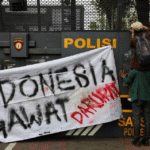 Seorang mahasiswa membakar ban dan barang-barang lainnya di dekat barikade polisi dalam aksi protes pada peringatan satu tahun pemerintahan Presiden Prabowo, yang mengkritik kebijakan pemerintah termasuk program makanan gratis, di Jakarta, Indonesia, 20 Oktober 2025. REUTERS/Willy Kurniawan