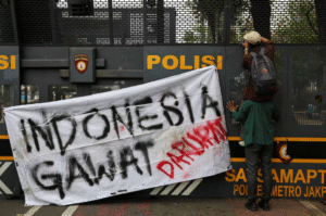 Seorang mahasiswa membakar ban dan barang-barang lainnya di dekat barikade polisi dalam aksi protes pada peringatan satu tahun pemerintahan Presiden Prabowo, yang mengkritik kebijakan pemerintah termasuk program makanan gratis, di Jakarta, Indonesia, 20 Oktober 2025. REUTERS/Willy Kurniawan